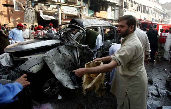 Security officers collect evidence from the site of a suicide bomb attack in Peshawar